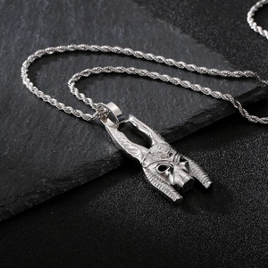 Macro view of silver Anubis mask pendant on twist chain over black stone base