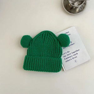 Detailed knit texture of green winter beanie featuring cute soft 3D bear ears
