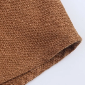 Close-up of the breathable brown linen fabric texture showing the natural weave detail