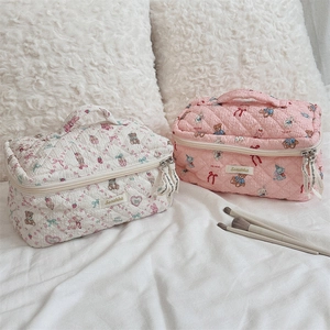 Detailed view of pink and white quilted cosmetic bags with cute teddy bear and rabbit patterns