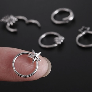 Surgical steel star spider nose ring and cartilage earring shown in a close-up view