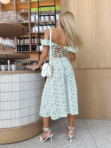 Detail of cross-straps on an off-shoulder floral midi dress with an elegant backless design