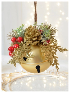 Detailed view of gold Christmas bell ornament with pine cones and red berries detail