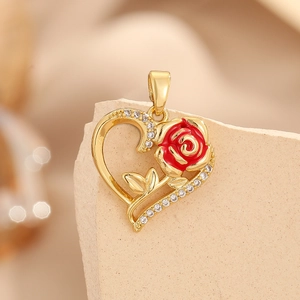 Close-up of a heart-shaped gold pendant with a red enamel rose and sparkling white zircons