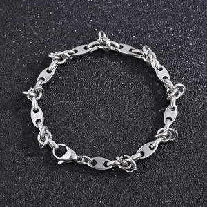 Macro detail of silver titanium steel coffee bean links on a sleek knot chain bracelet