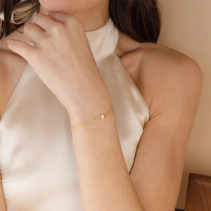 Close-up of a double-layer gold silver bracelet with a four-prong set white zircon