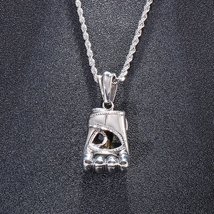Detail of silver boxing glove pendant in titanium steel with dark textured stone inlay