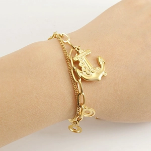 Bracelet double couche en acier titane doré avec pendentif ancre porté par une femme