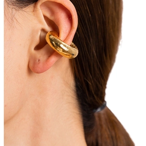 Elegant gold hollow ear cuff with hammered texture on female model without ear piercing