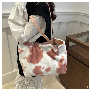 Close-up of pink cow print plush tote bag with premium leather texture shoulder strap