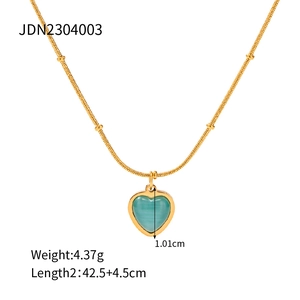 Detail shot of a minimalist gold necklace with a teal heart opal pendant on a white base