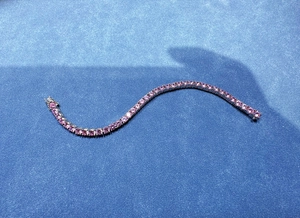 Dettaglio del bracciale tennis con diamanti rosa da 5mm su sfondo di velluto blu