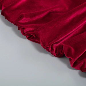 Gros plan détaillé de la texture luxueuse du velours rouge avec plis plissés naturels