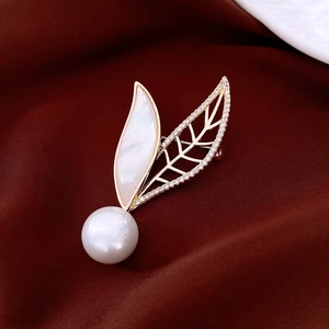 Detailed macro view of 18k gold plated pearl butterfly brooch with zircon inlays