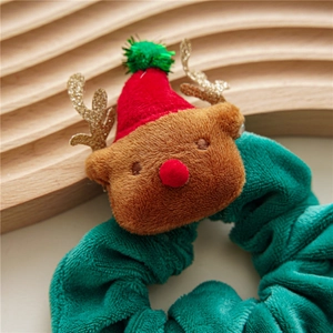 Close-up of a green plush scrunchie with a cute 3D Christmas reindeer and red festive hat