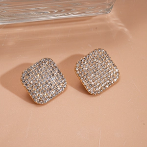 Close-up of gold square pave stud earrings featuring sparkling crystal rhinestones
