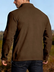 Outdoor rear view of a man wearing a thick brown fleece quarter-zip sweatshirt in nature
