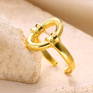 Detailed view of intertwined gold snake ring on a natural stone textured background
