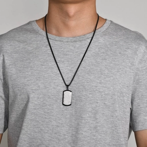 Close-up of a men's rectangle dog tag necklace with silver hammered texture on black chain