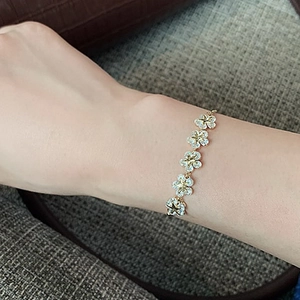 Close-up of adjustable flower charm bracelet with star-shaped rhinestones on wrist