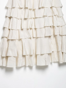 Close-up of layered ivory ruffled hem with satin texture on elegant puff skirt