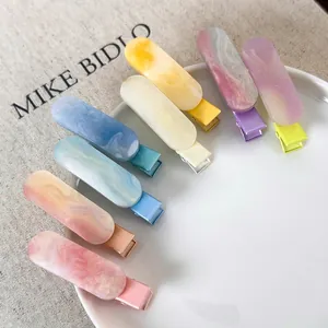 Morandi colored marble resin duckbill hair clips set for women in a white ceramic plate