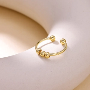 Detail of 18K gold-plated rotating fidget ring with movable gold beads and open band
