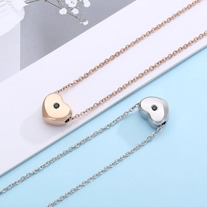 Close-up of heart-shaped pendants with black stones in rose gold and silver finish