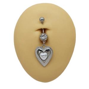 Macro detail of heart belly ring with white bead and clear crystal on silicone skin