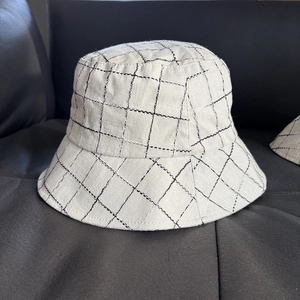 Close-up of linen blend bucket hat featuring a white and black windowpane check pattern