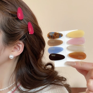 Détail de pinces à cheveux en acrylique avec lettrage doré France Handmade élégant