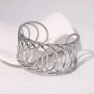Detail view of silver hollow layered cross bangle on a white aesthetic display stand
