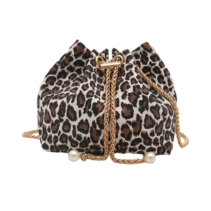 Leopard print bucket bag with gold chain drawstring and pearl accents on white background