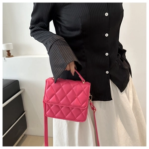 Vue détaillée du sac à main matelassé rose avec chaîne et poignée sur un modèle