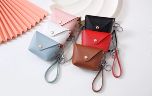 Detailed flat lay of colorful mini PU leather coin purses with metal clasps and wrist straps