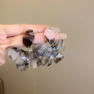Close-up of marble pattern acrylic flower earrings with artistic grey and white texture
