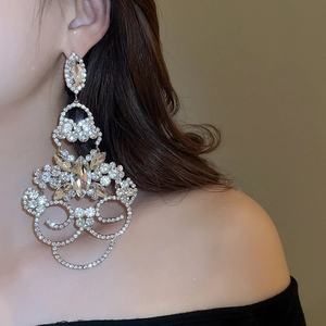 Gros plan de boucles d'oreilles pendantes à fleurs argentées avec cristaux brillants