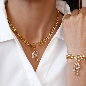 Detailed view of gold chunky chain jewelry set with rhinestone lock and key pendants