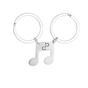 Close-up of split musical note stainless steel keychains that interlock for couples