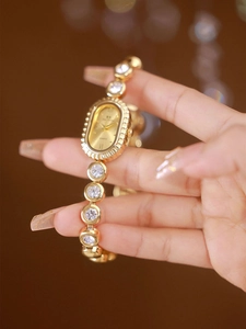 Close-up of a luxury gold quartz watch for women with rhinestones and Roman numerals