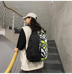 Side view of black and green camo backpack with side straps and decorative zip puller