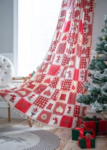 Detailed view of festive Christmas curtain with red patchwork and decorative tassels