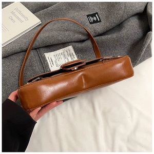 Close-up of caramel brown punk style shoulder bag with silver metallic hardware detail