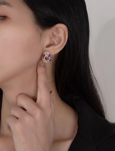 Detailed view of sterling silver rainbow crystal studs worn on a female ear