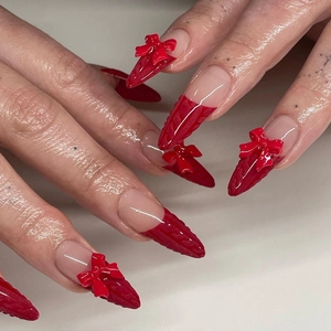 3D red French press-on nails with stiletto shape, sweater texture, and festive bows