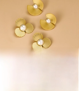Détail de boucles d'oreilles en acier titane doré avec trèfle, éventail et perles