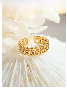 Nahaufnahme der goldenen Kettenglied-Ring mit verstellbarem Design auf weißem Dekostein