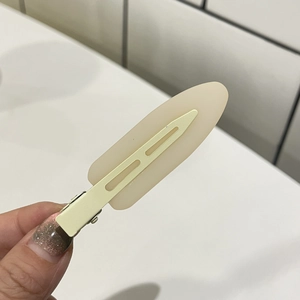 Detail view of cream resin seamless hair clip with matte finish and metal duckbill base