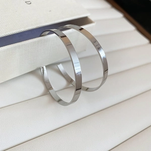 Macro shot of polished silver metal hoop earring on a luxury jewelry display tray