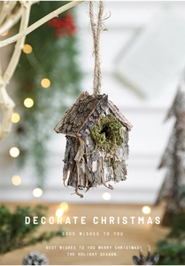 Détail d'une décoration cabane à oiseaux en écorce et mousse suspendue à une branche